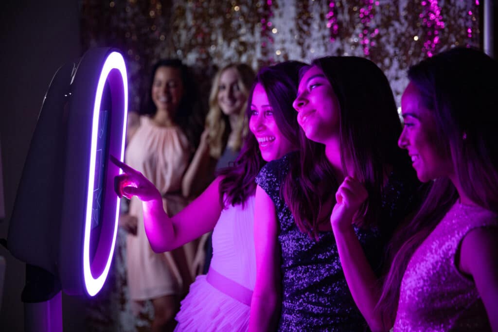 Group of women interacting with a photo booth setup