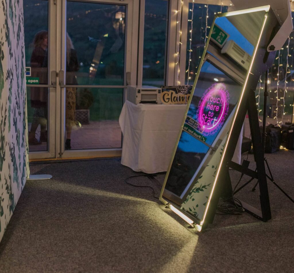 Mirror photo booth setup in front of a backdrop