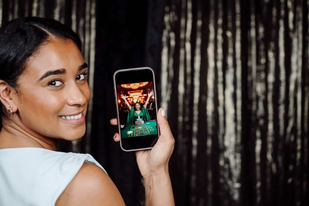 Woman holding her phone showing an image taken with a photo booth