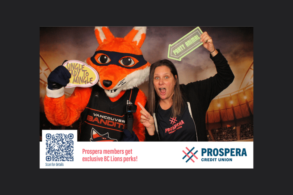 Woman and mascot holding signs taking a picture together.